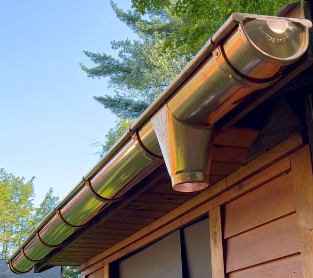 New half-round copper gutter on a wooden eave, complementing old world historic look.